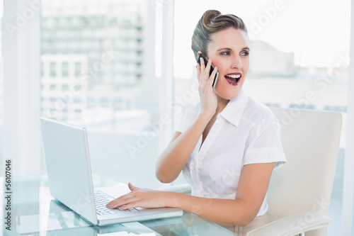 Happy businesswoman talking on the phone sitting