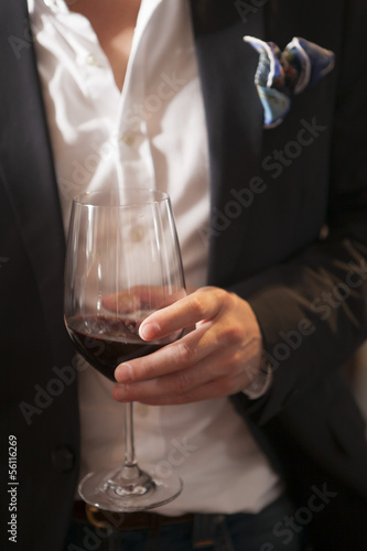 Man holding glass of red wine in party