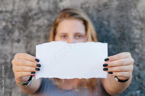 teenage girl in casual clothes holding blank sheet of paper