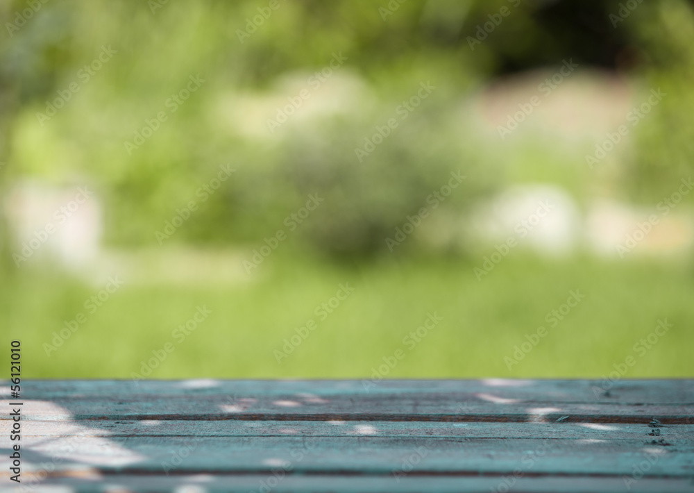 Wooden table against a blurred green background Wooden table against a blurred green background