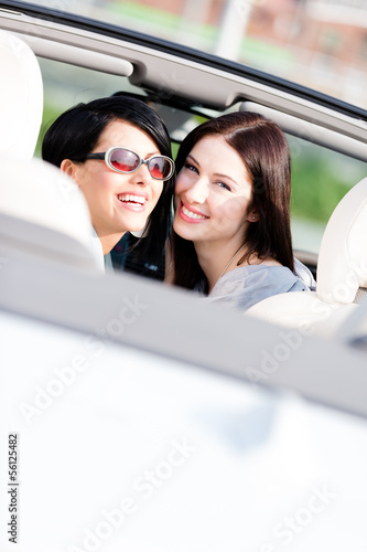 Two happy girls sitting in the car look back and have fun © Karramba Production