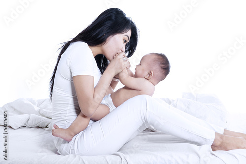 Beautiful mother kissing baby - isolated