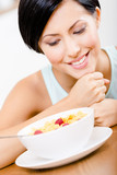 Close up view of girl near the plate with muesli and strawberry 