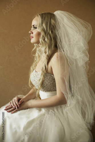 portrait of a beautiful blonde bride over wooden background