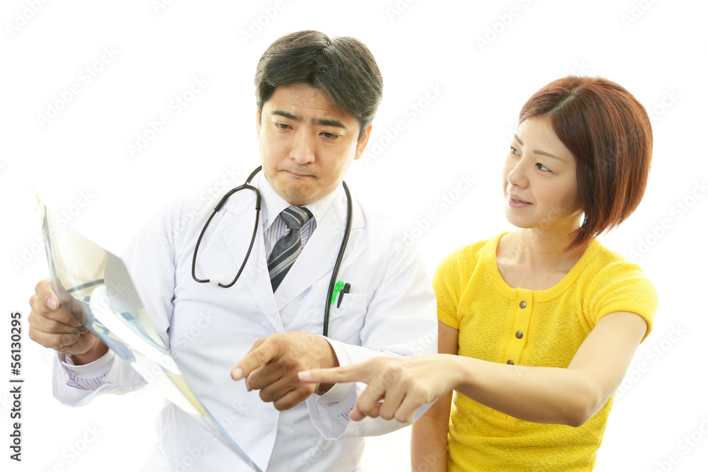 真剣な表情の医師と女性患者 真剣な表情の医師と女性患者