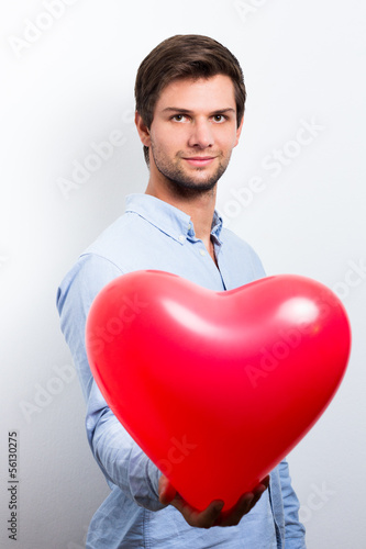 Man holding a red heart balloon © dandaman