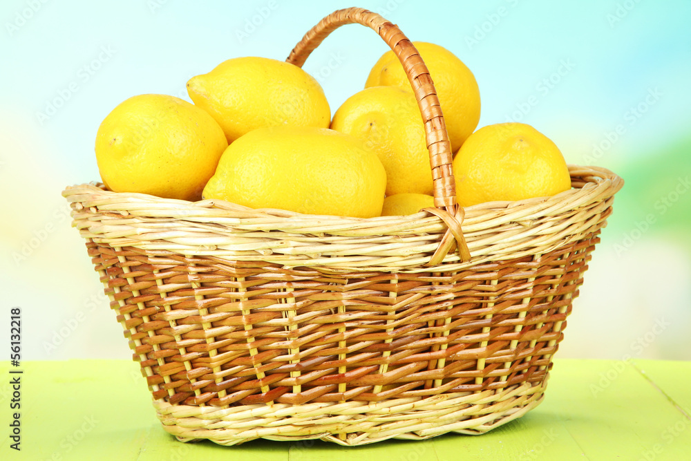 Ripe lemons in wicker basket on table on bright background Ripe lemons in wicker basket on table on bright background