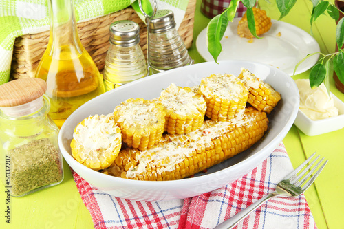 Flavored boiled corn on plate on wooden table close-up
