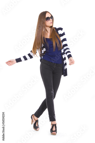 Pretty young woman in stripy shirt and jeans posing