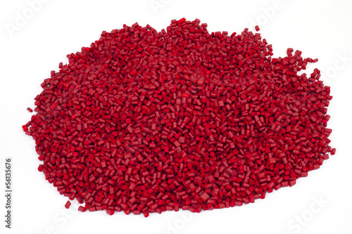 red plastic polymer granules on white background