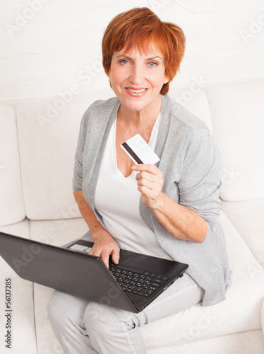 Mature woman with credit card and laptop