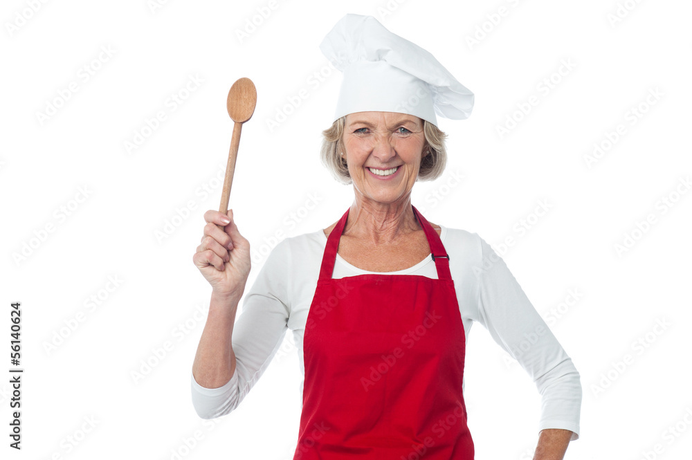 Happy aged chef holding wooden spoon Happy aged chef holding wooden spoon