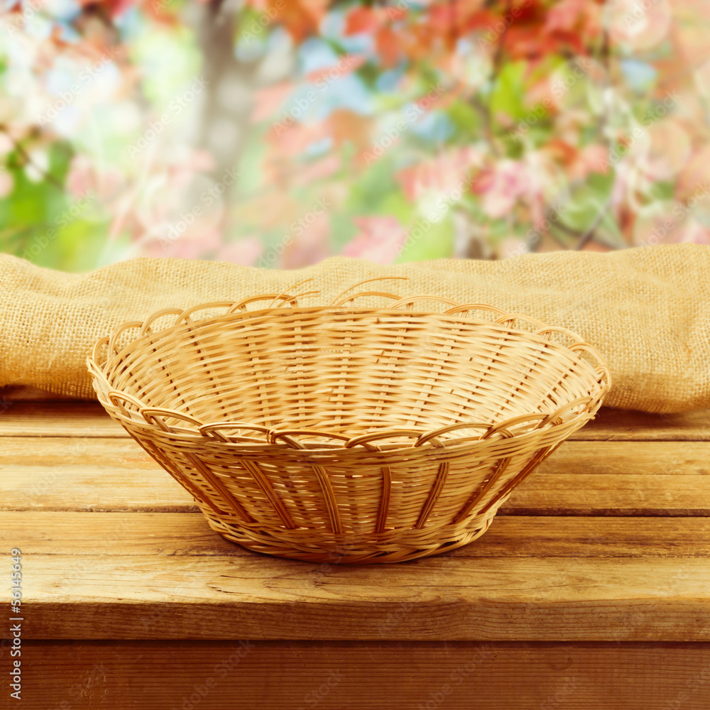 Empty basket on wooden table over bokeh autumn background Empty basket on wooden table over bokeh autumn background