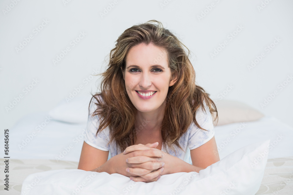 Portait of smiling woman lying on bed Portait of smiling woman lying on bed