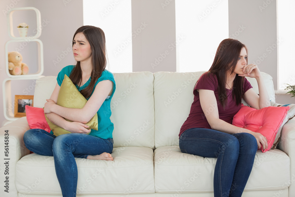 Two friends not talking to each other after fight on the sofa Two friends not talking to each other after fight on the sofa