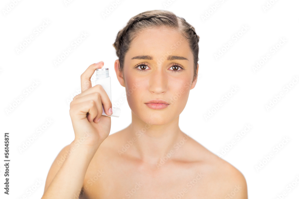 Gloomy young model holding asthma atomizer