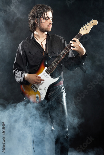 Psychedelic rock guitarist with long brown hair and beard. Dress