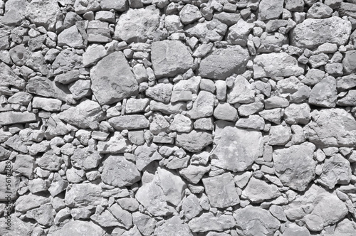 grey old wall made of big and little stones