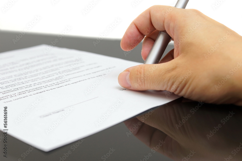 businessman examines the articles of agreement before signing businessman examines the articles of agreement before signing