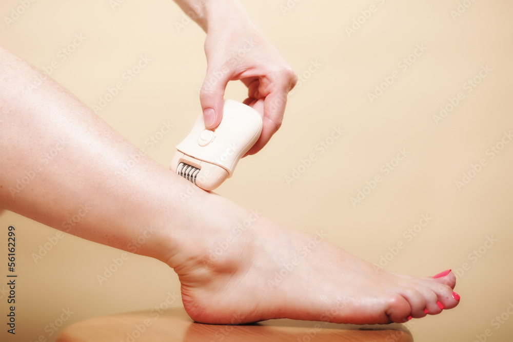 Fototapeta premium woman shaving leg with shaver depilation body care