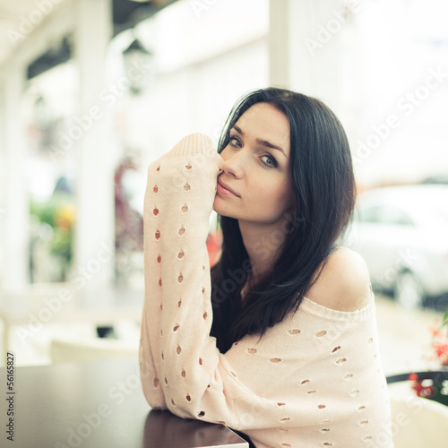 portrait of a beautiful brunette in a cafe