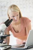 Student Using Laptop And Microscope