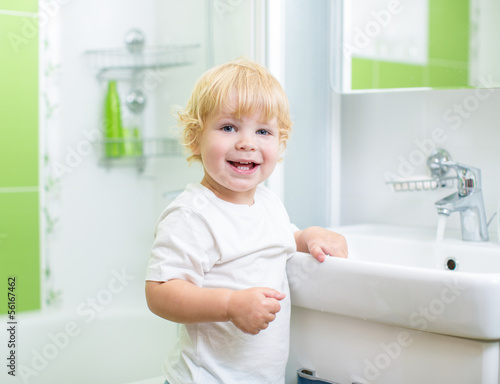 Fototapeta Happy kid washing in bathroom