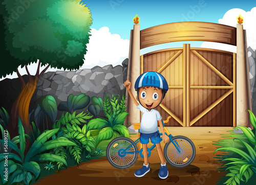 A boy in the frontyard with a bike