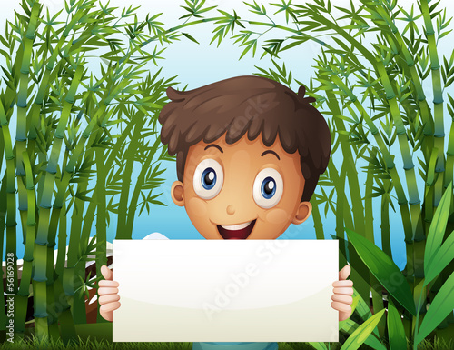 A boy at the bamboo farm holding an empty signage photo