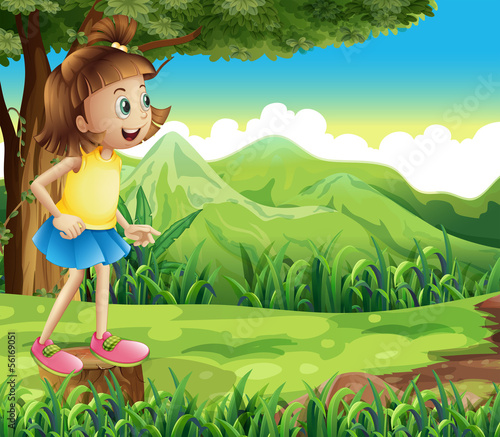 A happy girl standing above a stump at the hill