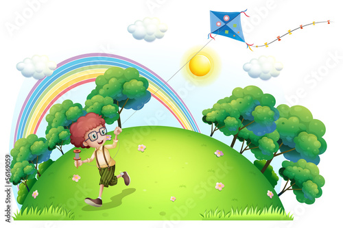 A boy playing with his kite at the hilltop