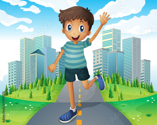 A boy waving while running in the middle of the road