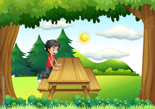 A wooden bench with a young boy at the forest