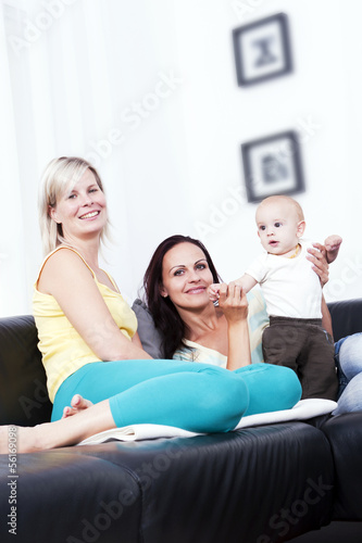 Mother and girlfriend in the living room of identical baby.