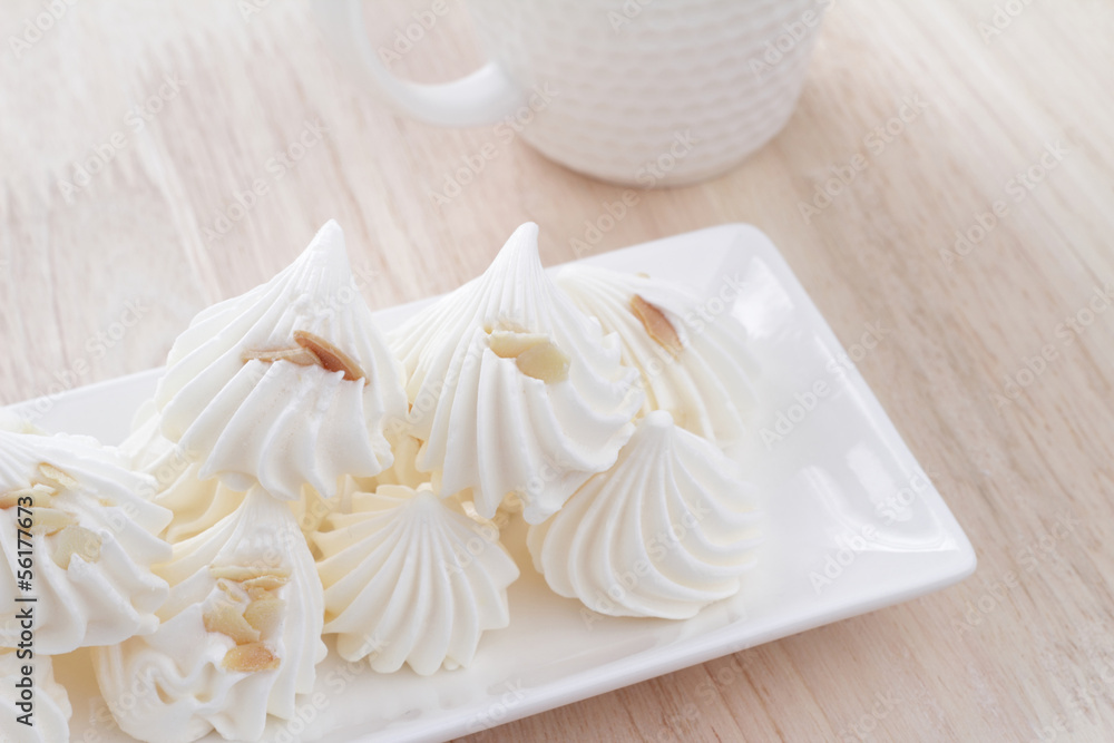 Meringue dessert placed in white dish on wooden table. Meringue dessert placed in white dish on wooden table.