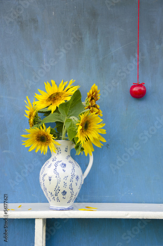 Fototapeta Naklejka Na Ścianę i Meble -  sunflowers beautiful bouquet in  pitcher with red apple