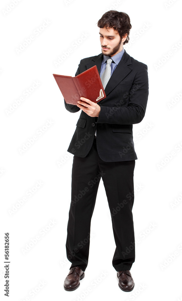 Full length businessman reading his agenda Full length businessman reading his agenda