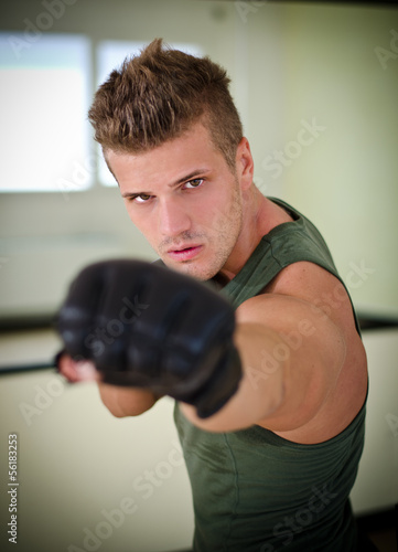 Handsome young man with boxer's gloves