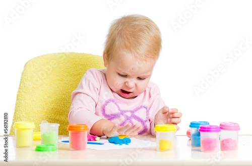 Happy kid girl playing with colorful clay toy