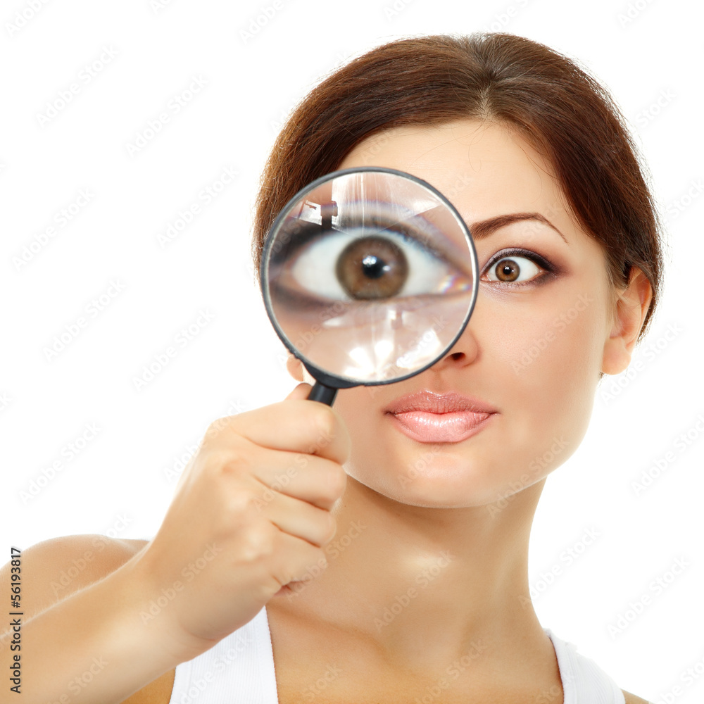 Smiling attractive woman looking through a magnifying glass over Smiling attractive woman looking through a magnifying glass over