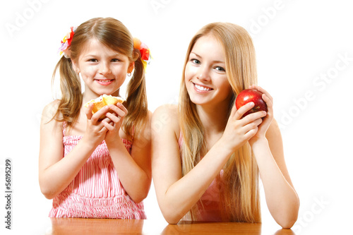 happy teeny girl with red apple and little girl with cake, photo