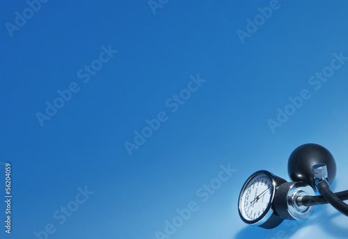 Sphygmomanometer on blue, reflective background