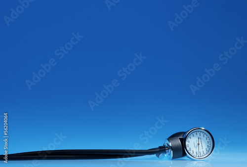 Sphygmomanometer on blue, reflective background