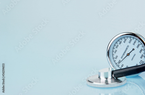 Stethoscope and sphygmomanometer on blue background photo