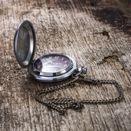 Old pocket watch at weathered wood board