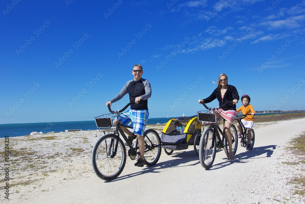 Fototapeta premium Family on a beach bicycle ride together