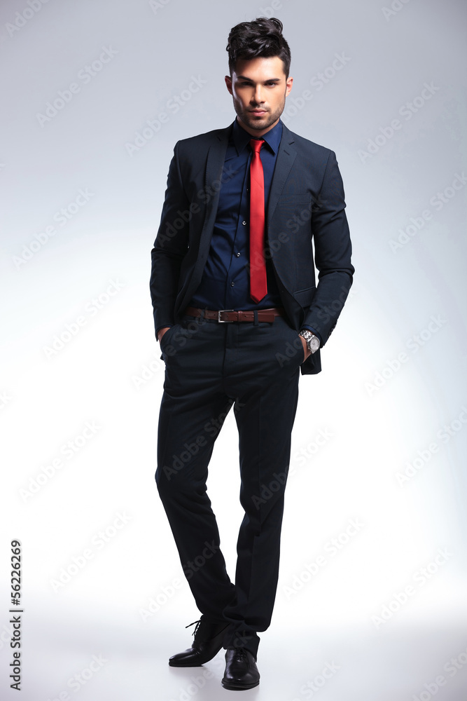 business man looks at you with hands in pockets business man looks at you with hands in pockets