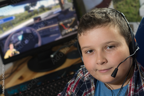 Boy with headphones is playing a computer game photo