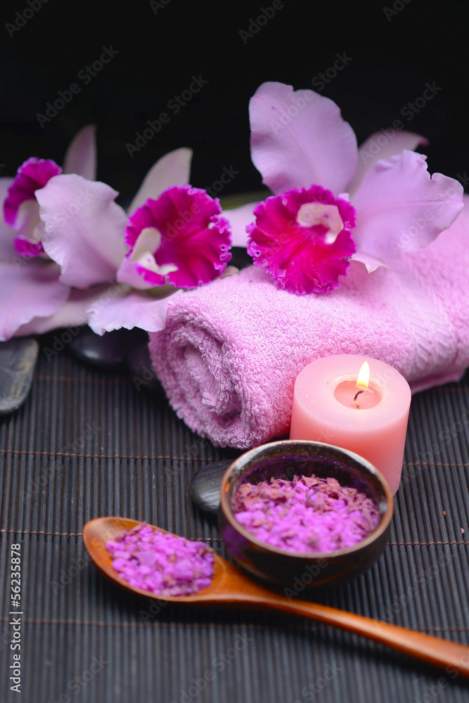 Beautiful pink orchid on towel and candle, salt in bowl on mat Beautiful pink orchid on towel and candle, salt in bowl on mat