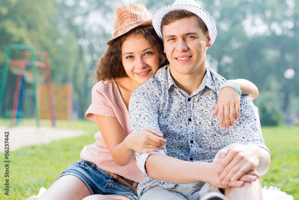 couple lying on the grass in the summer park